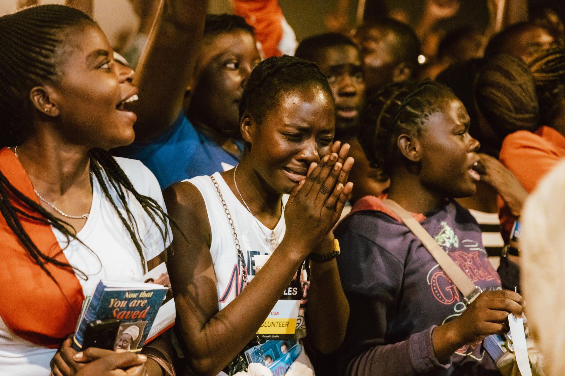 Volunteers worshipping and praying together at a community outreach gathering